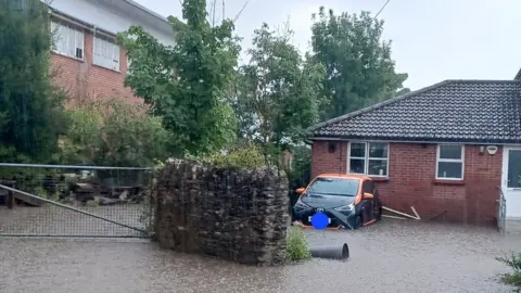 Luke Phillips/PA Wire Flooding outside a house in Port Talbot, Wales