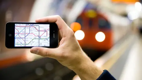 Getty Images Man holds phone on London Underground