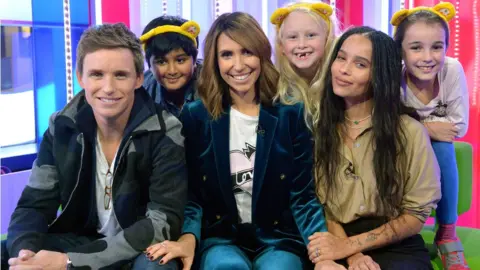 PA Eddie Redmayne and Zoe Kravitz played a joke on The One Show presenter Alex Jones with the help of (left to right) Vidhit Nihal, 8, Kelsey Wheatley, 7, and Lucy Subbiah, 9 during The One Show for BBC Children in Need