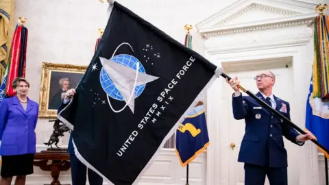 Getty Images Man holding US Space Force flag.