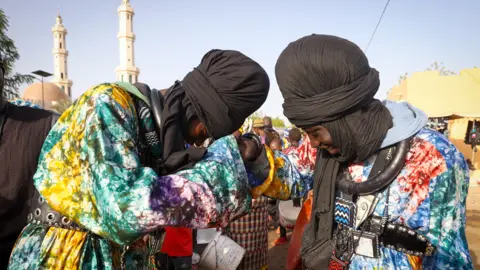 Cem Ozdel/Getty Images Two Baye Fall members greet each other in Diourbel, Senegal - Friday 5 April 2024