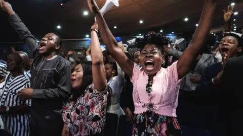 Getty Images Worshippers of the Nigerian Pentecostal church Salvation Ministries attend the 5th Sunday service at their church headquarters in Port Harcourt, southern Nigeria, on February 24, 2019