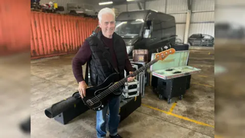 Leigh Milner/BBC Phil Mitchell holding his guitar