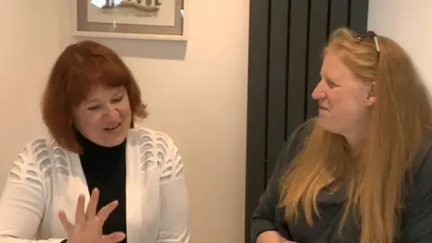 Maryna (left) and Vicki sitting around kitchen island