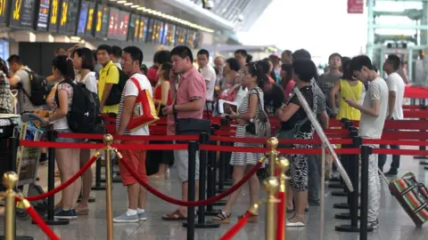 Getty Images Chinese travellers at Zhengzhou Xinzheng International Airport in Zhengzhou, central China