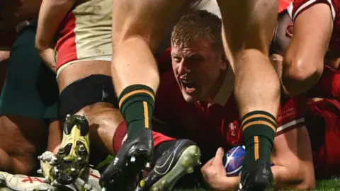 Getty Images Jac with the ball in his hand on the ground beneath a pile of players shouting