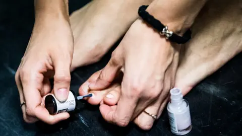 Getty Images Someone painting their toenails on the train