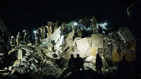 AFP Rescuers remove debris to search for survivors at a destroyed apartment building hit by a rocket during the night in downtown Kramatorsk