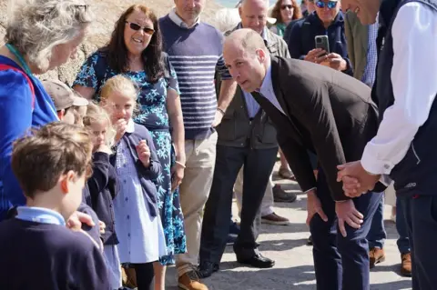 PA Media William meets schoolchildren during a visit to St Mary’s Harbour eiqrhiqqdidtinv