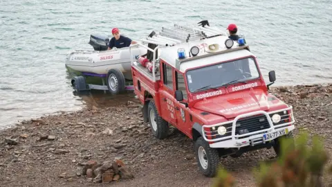 PA Media Firefighters drop dinghy into reservoir