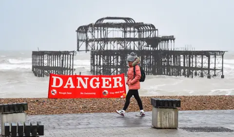 Alamy Live News A walker passes by a Danger sign on Brighton on 18 February 2022