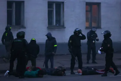 Getty Images Police hold demonstrators face-down on the floor on 25 October