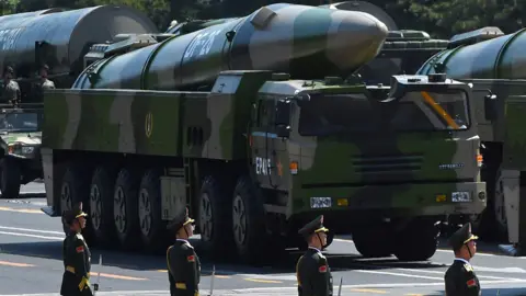 Getty Images Military vehicles carry DF-26 missiles during a parade in Beijing