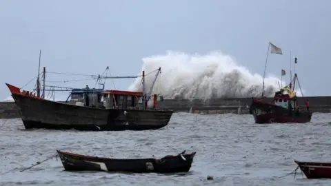 Reuters Waves crash against the jetty at a fishing harbour ahead of the expected landfall of Cyclone Vayu at Veraval, India, June 12, 2019