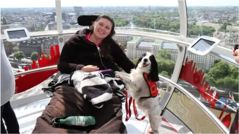 Lucy Watts Lucy Watts on the London Eye with her support dog Molly