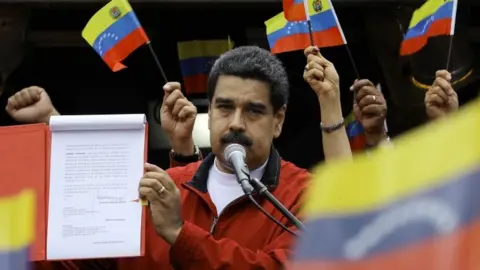 Reuters Venezuela's President Nicolas Maduro shows a document with the details of a "constituent assembly" to reform the constitution during a rally at Miraflores Palace in Caracas, Venezuela May 23, 2017.