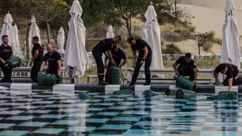 AFP French firefighters fill canisters in a swimming pool