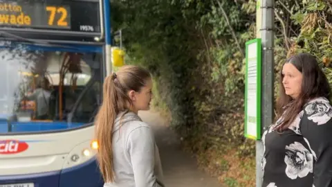 Jon Ironmonger/BBC Emily and Clare Sheterline by a bus