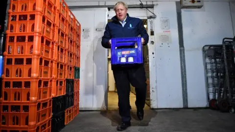 Getty Images Boris Johnson carries crate of milk