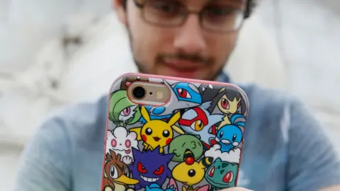 Getty Images Gamer with a Pokemon phone