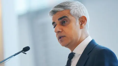 PA Media Sir Sadiq Khan speaking into a microphone 