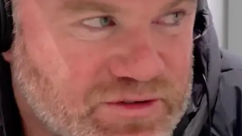 Close up photo of Wayne Rooney's face. He has ginger and grey facial hair.