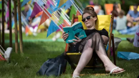 Getty A woman in a deckchair reading a book at Hay Festival