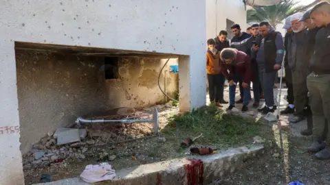 Palestinians look at the scene of a deadly Israeli drone strike in the village of Tammun, in the north of the occupied West Bank (8 January 2025)