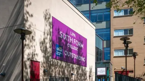 A cream building has a purple sign on its side which reads LIPA SIXTH FORM COLLEGE. 