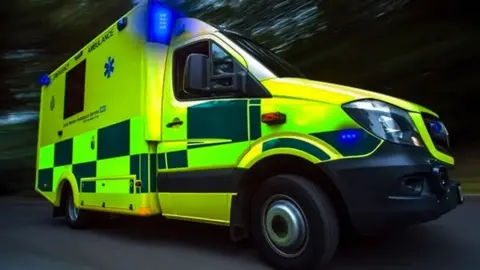 A yellow and green checked ambulance with blue lights on.