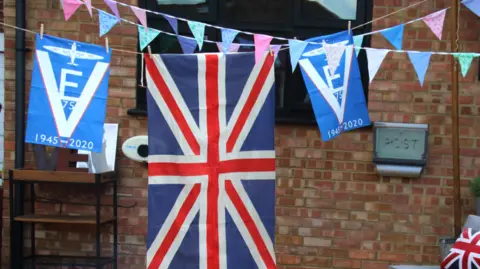 Getty Images A union jack and commemorative flags shown outside a house to mark the 75th anniversary of VE Day in 2020