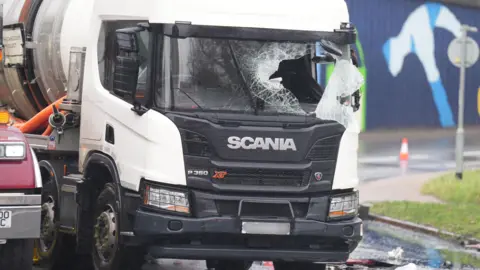 Eddie Mitchell La ventana delantera de un camión está destrozada.