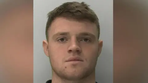 Devon and Cornwall Police A police mugshot of a man man with cropped brown hair and brown eyes staring straight ahead