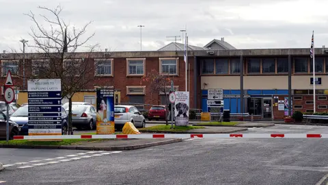 PAUL ELLIS/AFP via Getty Images General view of the front of HMP Long Lartin. A red and white barrier is in the foreground, with a car park behind and a long, two-storey building beyond that
