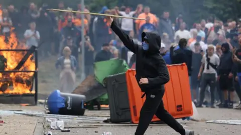  PA/Danny Lawson A man throws wood