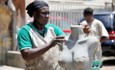 Akintunde Akinleye/EPA Motunrayo Aderupoko working on a mannequin at a workshop in Surulere district of Lagos, Nigeria - Monday 12 June 2023