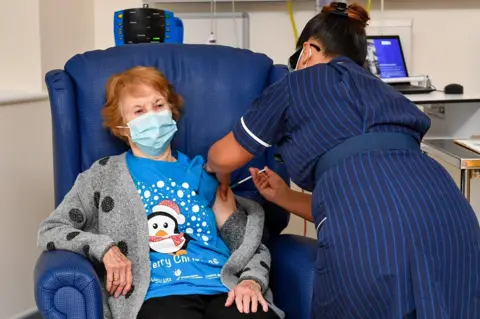 Jacob King / AFP Margaret Keenan receives a coronavirus vaccine from a nurse