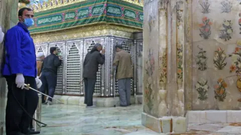 Getty Images Iranian sanitary workers disinfect Qom's Masumeh shrine