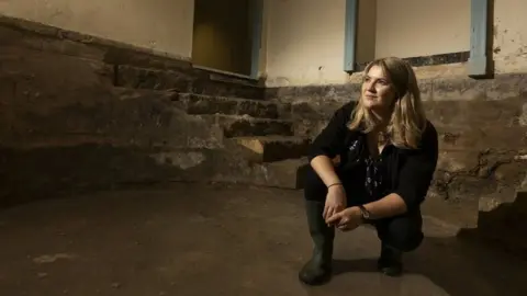 National Trust A woman sits in an 18th century cold bath.