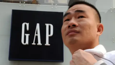 Getty Images Man walks past Gap store in China