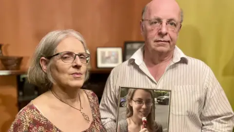 BBC/ Hazel Shearing Maggie and Bob Abrahart with a picture of their daughter