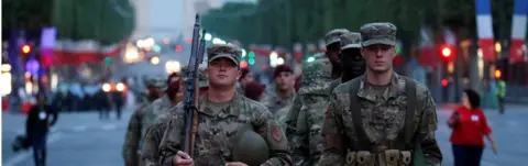 Reuters U.S. troops, with soldiers wearing WWI helmets, walk on the Champs Elysees during a rehearsal of the traditional Bastille Day military parade in Paris, France, July 10, 2017.