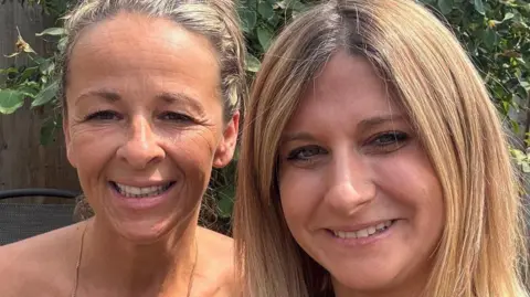 Two women smile to camera