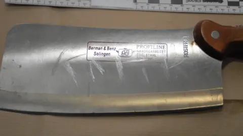 West Midlands Police Image of the cleaver with the word "kafir" inscribed onto the blade, found in a bag in Naweed Ali's car. Shown at the trial of Naweed Ali, Khobaib Hussain, Mohibur Rahman and Tahir Aziz