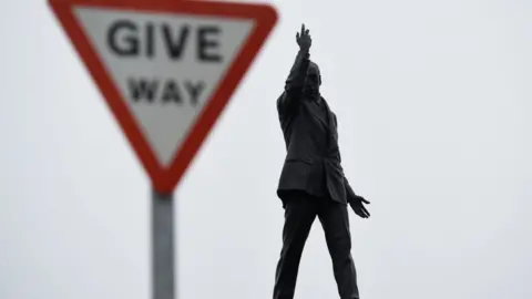 Reuters A give way sign beside the statue of Edward Carson at Stormont