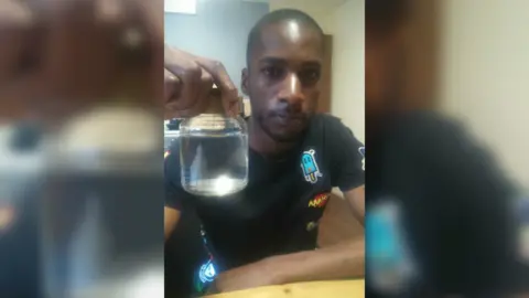 Matthew Rhone Matthew Rhone with a filled jar of drain fly larvae water