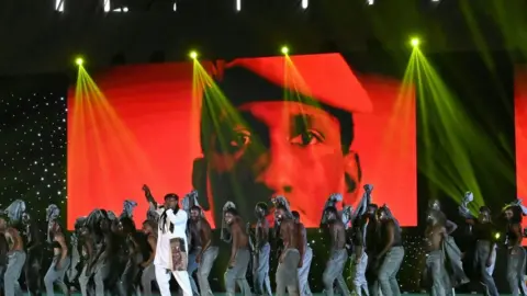 AFP Band performing on stage with a large image of Thomas Sankara in the background