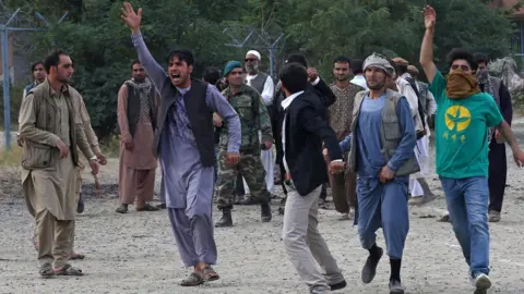 EPA People shout slogans at the scene of three bombings that targeted the funeral of a victim of the violent protests in Kabul