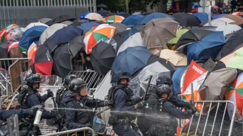 Getty Images A group of riot police try to attack the protester's front line in Hong Kong.