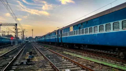 Getty Images Train On Railroad Track Against Sky During Sunset - stock photo